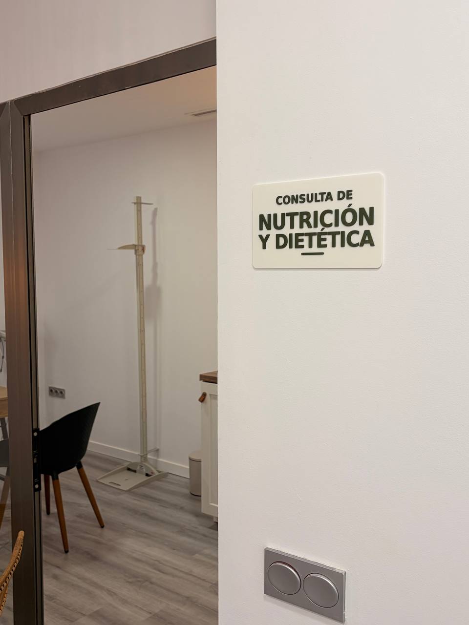 Rótulo CONSULTA DE NUTRICIÓN Y DIETÉTICA en la pared junto a la puerta de la consulta